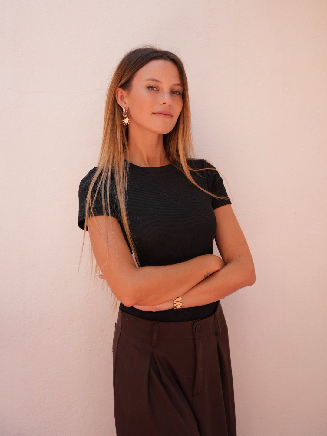 Portrait of Savannah Ellis in a black t-shirt against a pastel pink wall