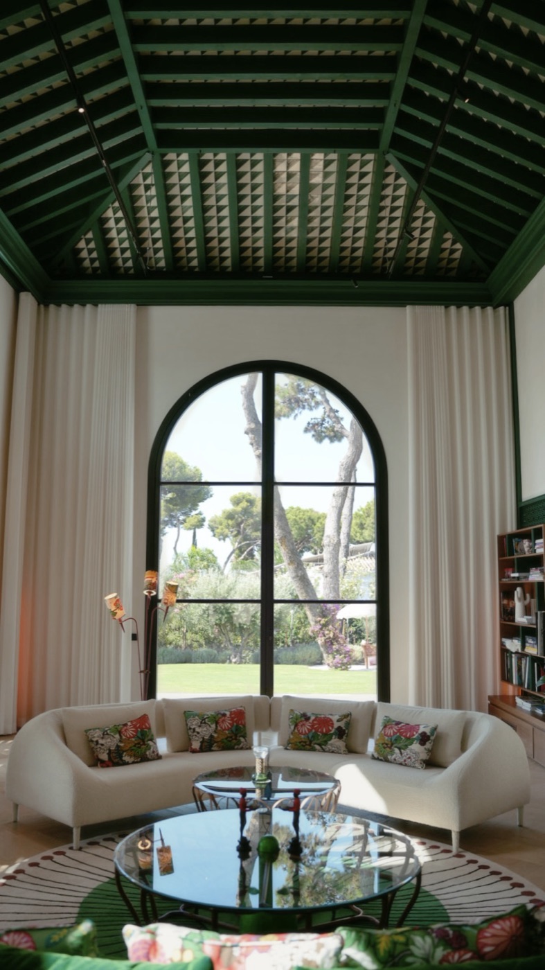 Luxury villa living room with a green vaulted ceiling and tall arched window onto the garden