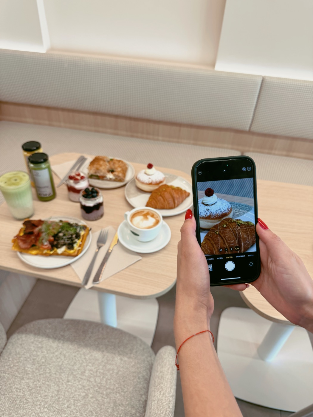 Filming a brunch spread of pastries, matcha and coffee on a phone