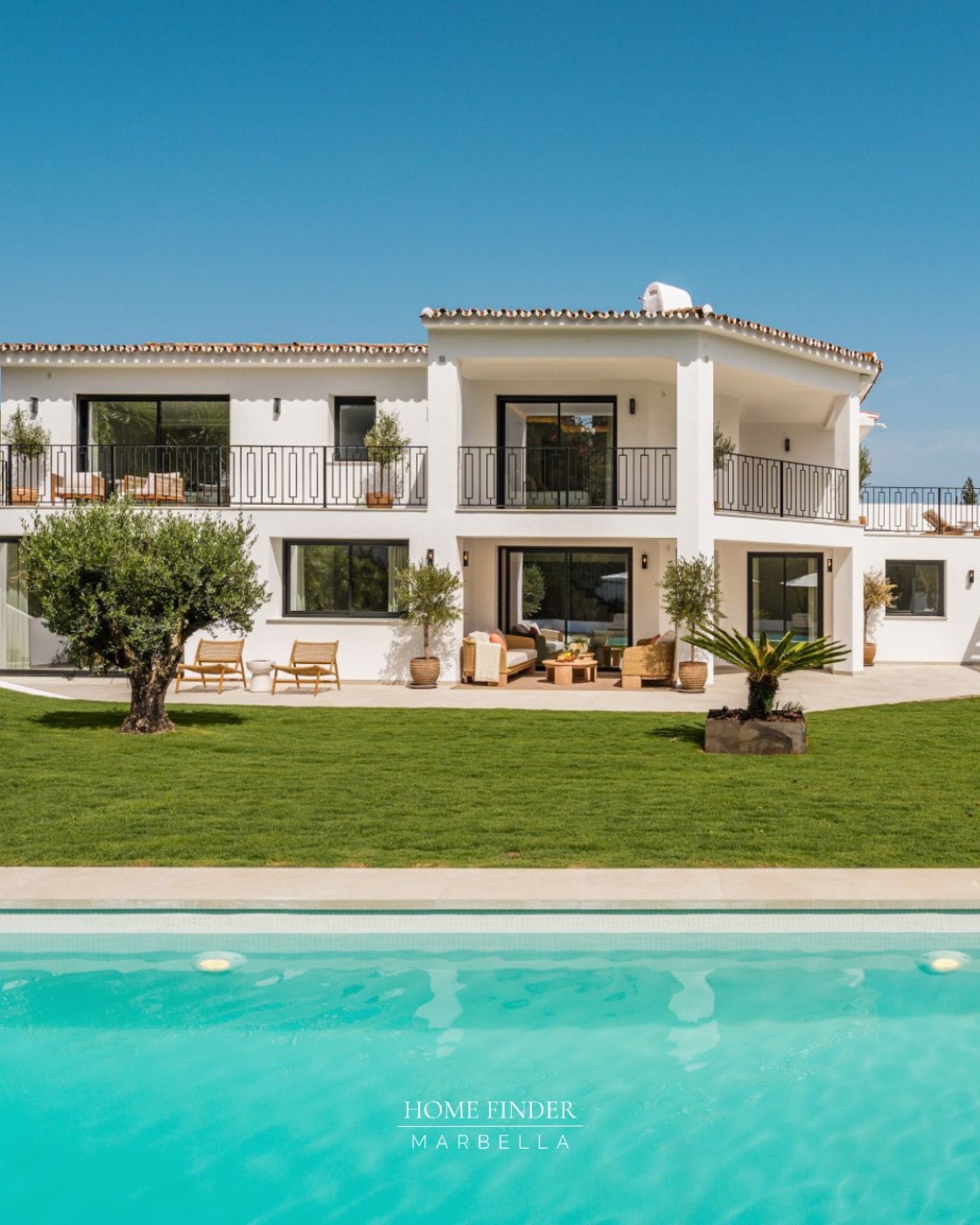 White Marbella villa with a turquoise pool and manicured lawn
